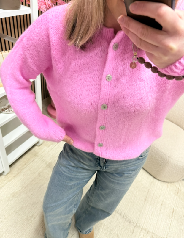 Model draagt gebreid vest Isa licht roze met een jeans – So Lucky