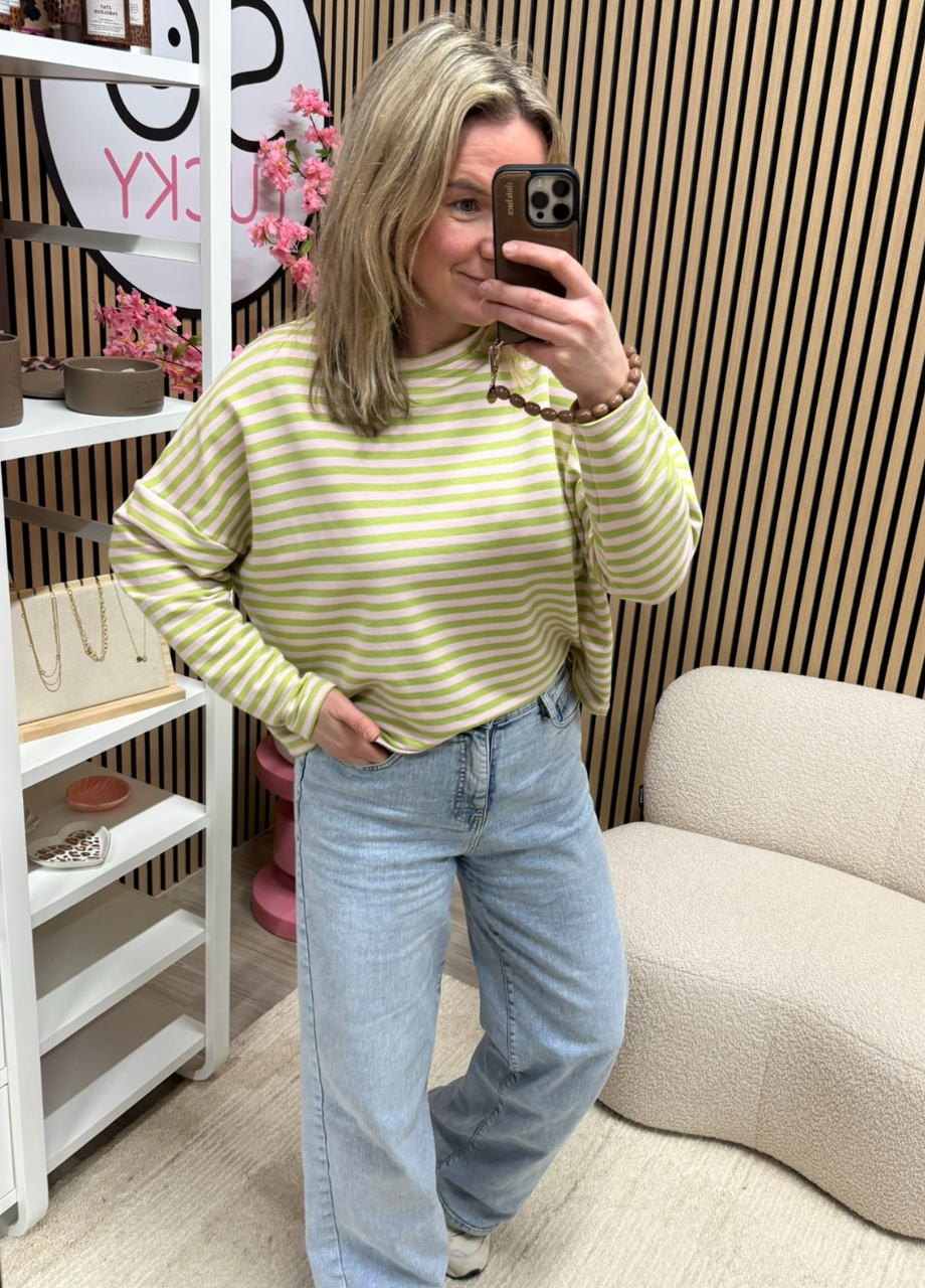 Longsleeve appelgroen lichtroze Model draagt gestreepte longsleeve appelgroen/lichtroze op een jeans – So Lucky