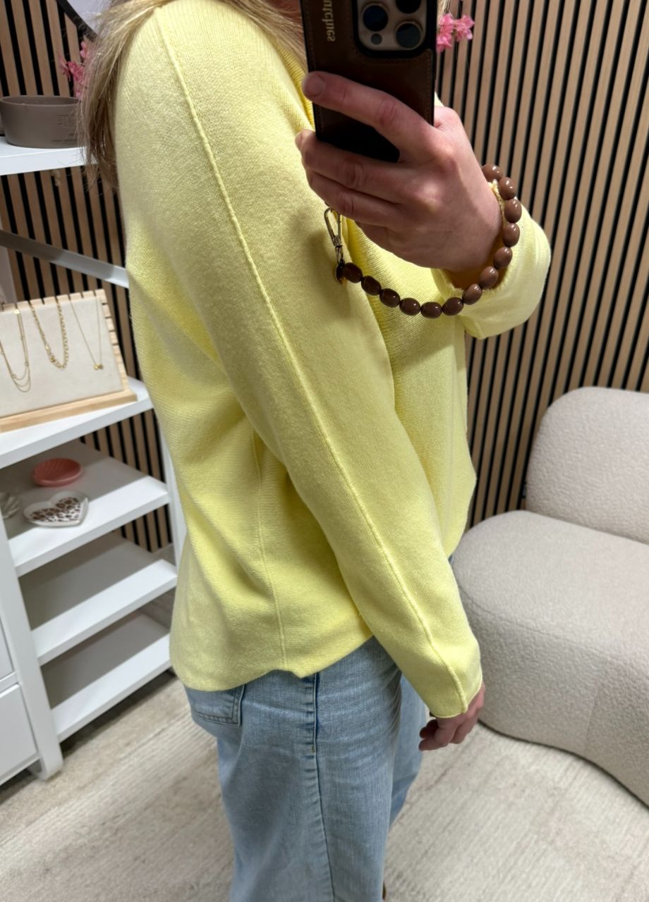 model draagt fijngebreide top botergeel diepe V-hals met jeans – So Lucky