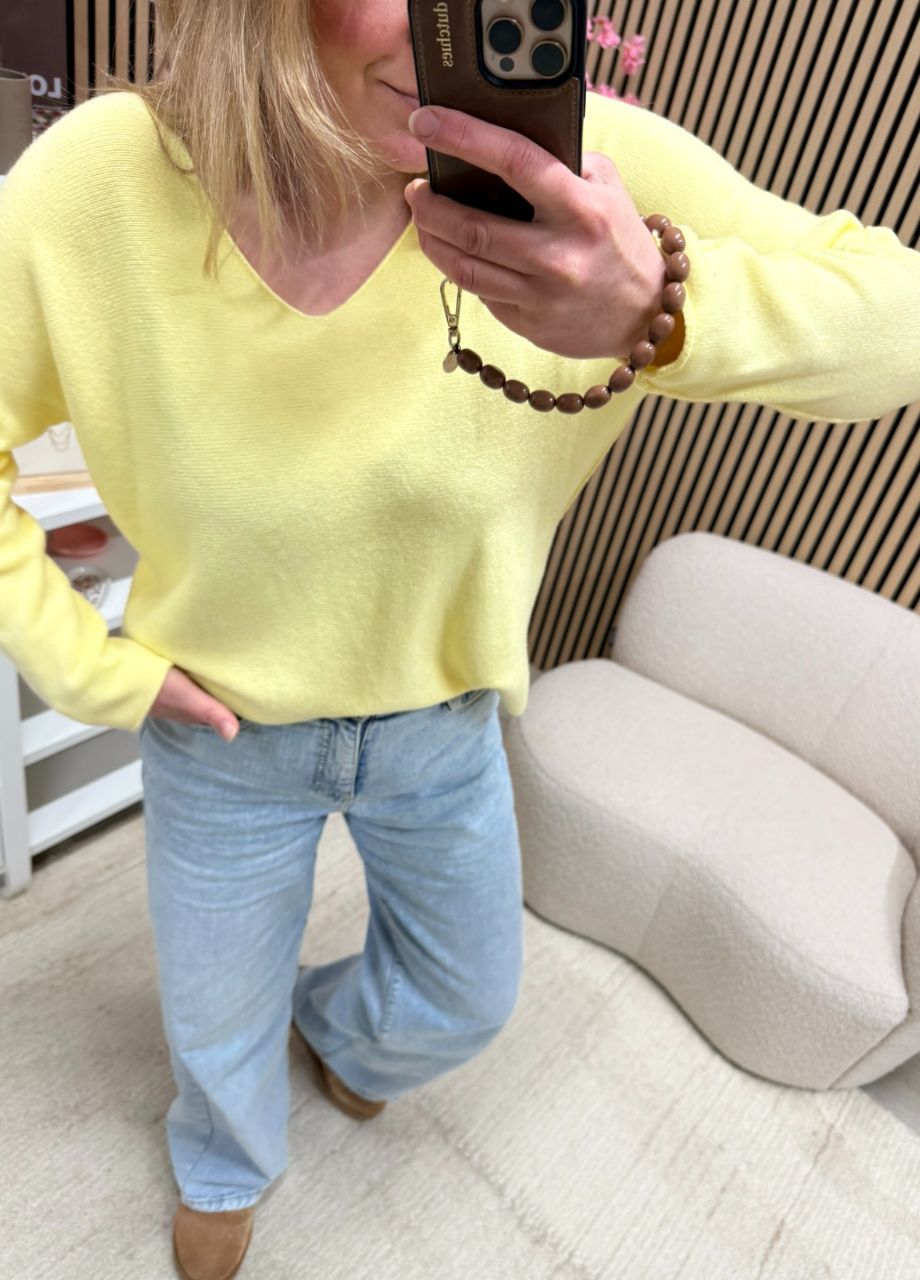 model draagt fijngebreide top botergeel diepe V-hals op een lichte jeans – So Lucky