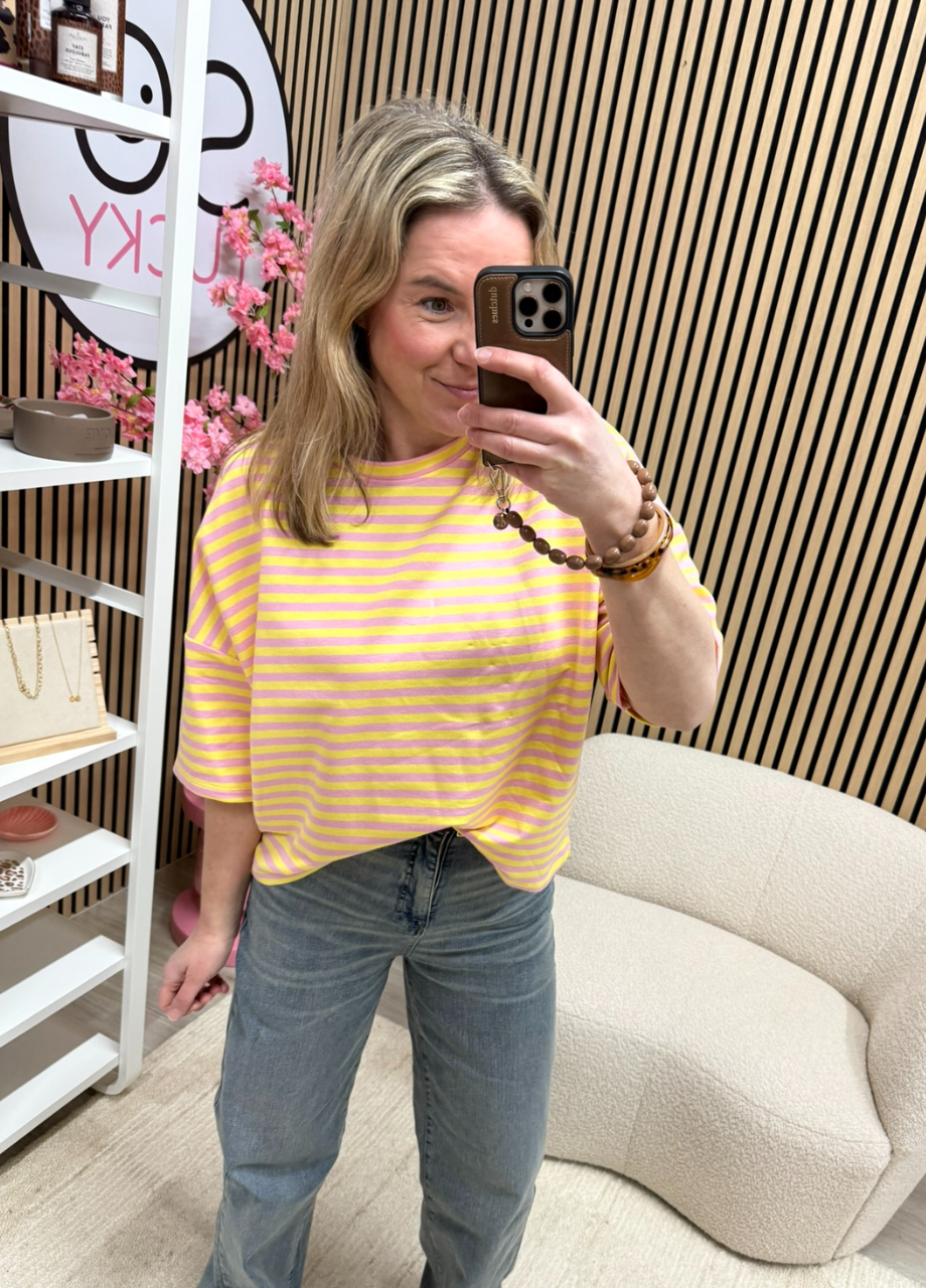 Gestreepte top Sanne – geel_roze (2) Model draagt gestreepte top geel roze op een jeans – So Lucky