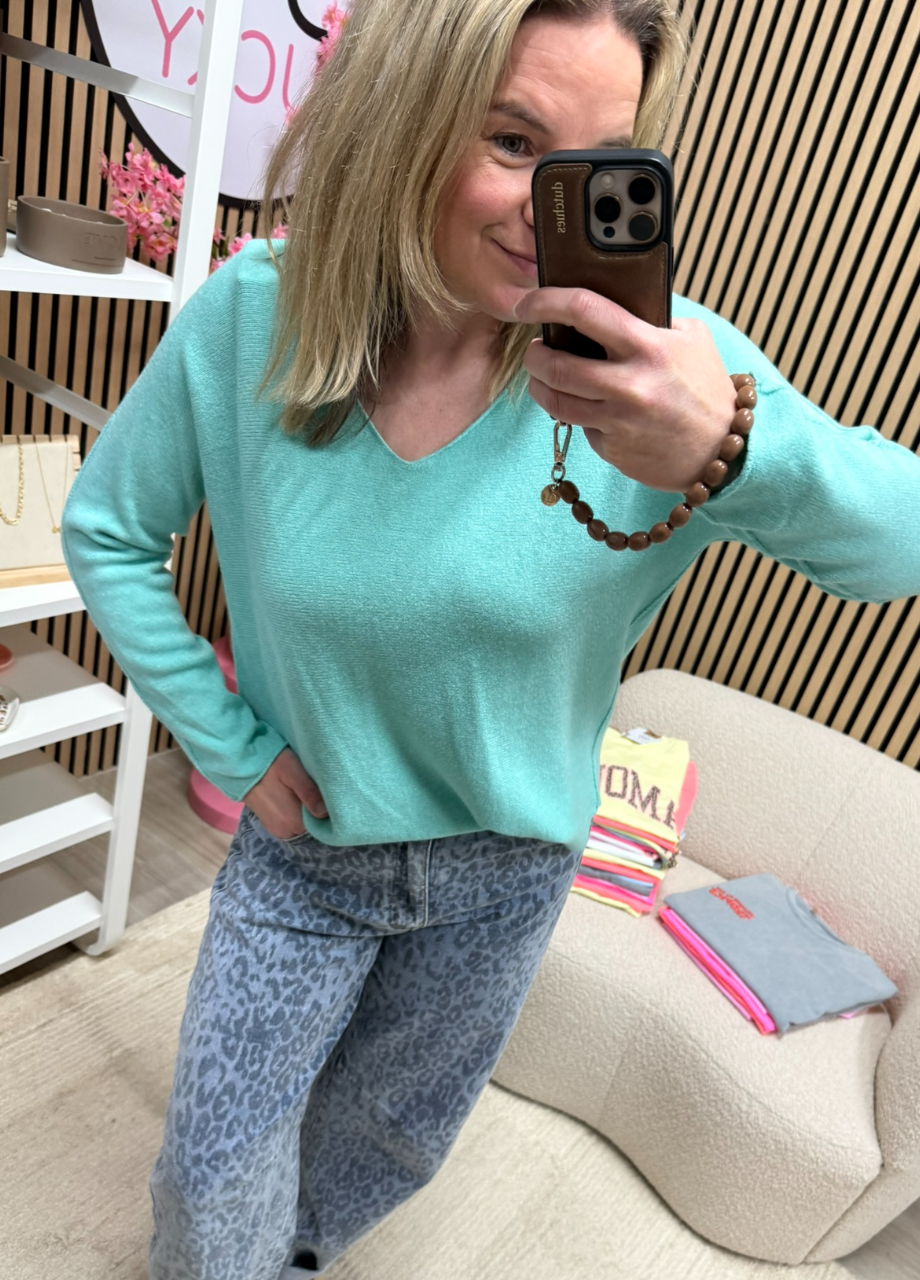 Fijngebreide top – groen – diepe V-hals model draagt fijngebreide top groen diepe V-hals op een jeans – So Lucky