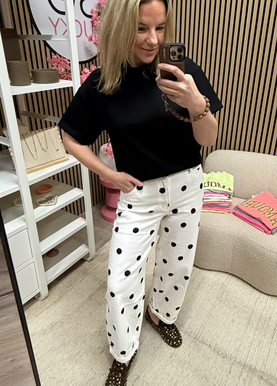 model draagt polka dot jeans balloon wit zwart met een zwart T-shirt – So Lucky