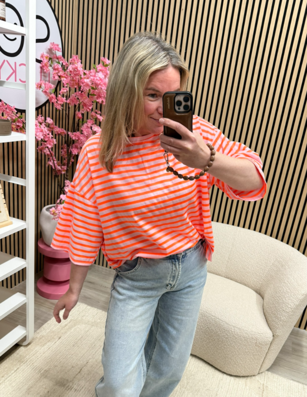 Model draagt het Oversized streepjes T-shirt Soleil neon oranje lichtroze losvallend – So Lucky