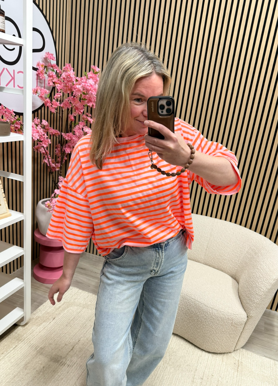 Model draagt het Oversized streepjes T-shirt Soleil neon oranje lichtroze losvallend – So Lucky