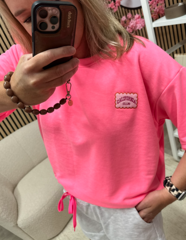 Model draagt Sweater T-shirt California Club neon roze – So Lucky