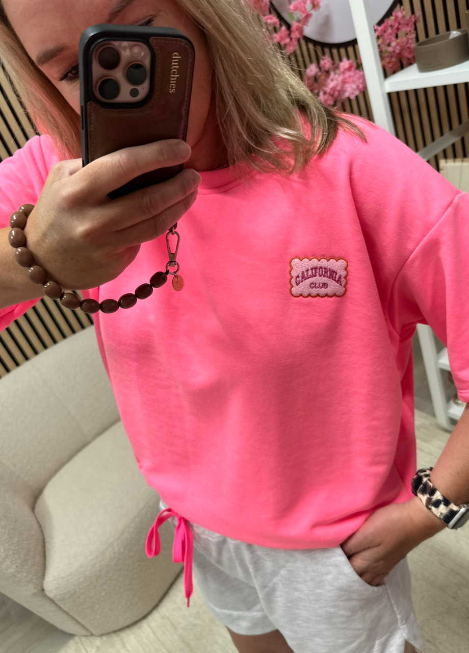 Model draagt Sweater T-shirt California Club neon roze – So Lucky