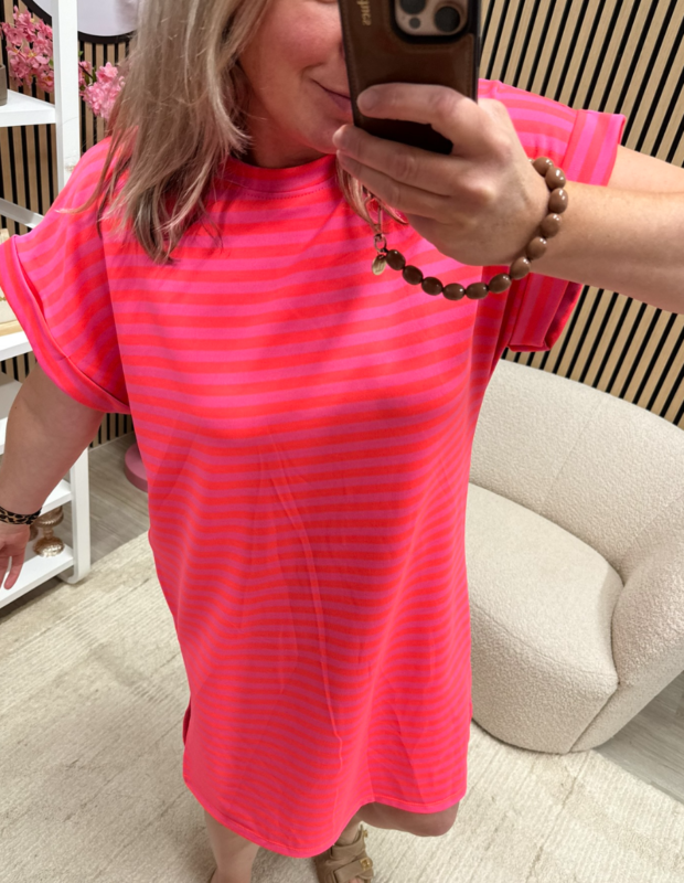 model draagt gestreepte jurk Belle roze neon oranje met slippers – So Lucky