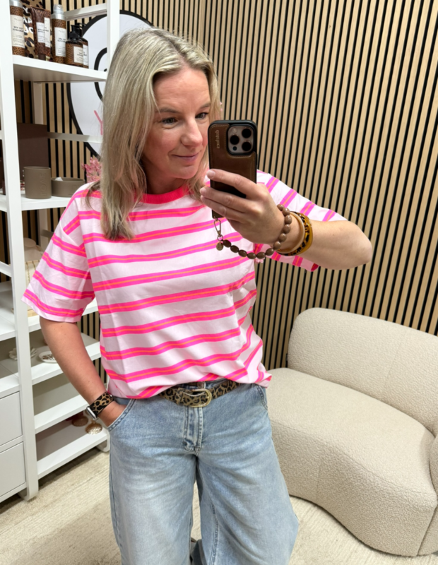 Model draagt T-shirt neon roze streepjes op een lichte jeans – So Lucky