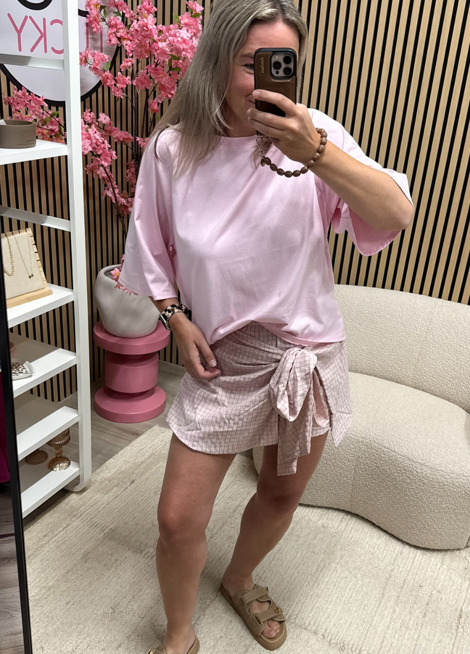 Skort Lu – lichtroze geruit Model draagt Skort Lu met strik - So Lucky
