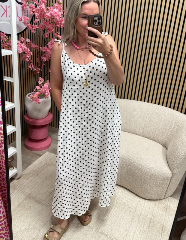 model draagt de mousseline jurk met strikbandjes wit zwart polka dots van 100% katoen – So Lucky