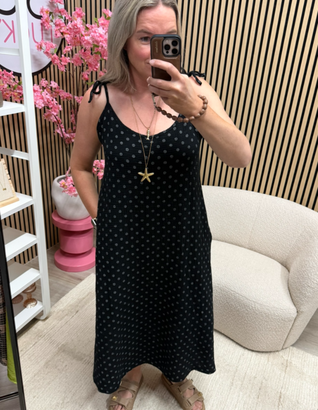 model draagt de mousseline jurk met strikbandjes zwart polka dots met sieraden – So Lucky