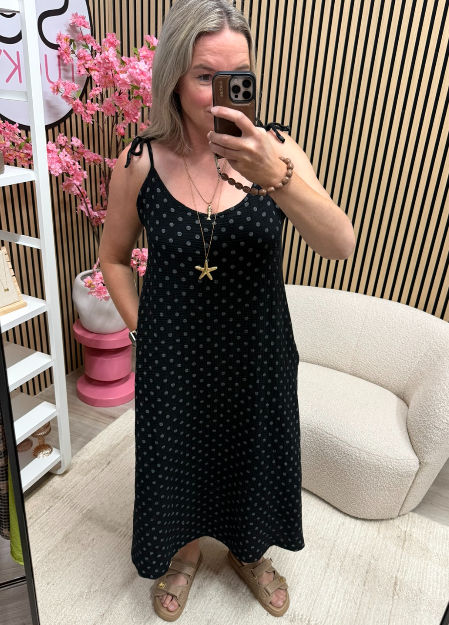 Mousseline jurk met strikbandjes – zwart polka dots (5) model draagt de mousseline jurk met strikbandjes zwart polka dots met sieraden – So Lucky