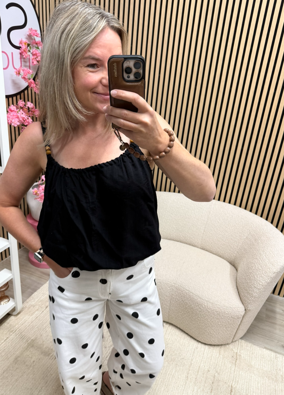 Top viscose met kraaltjes – zwart (4) Model draagt Top viscose met kraaltjes – zwart op een polka dot broek – So Lucky