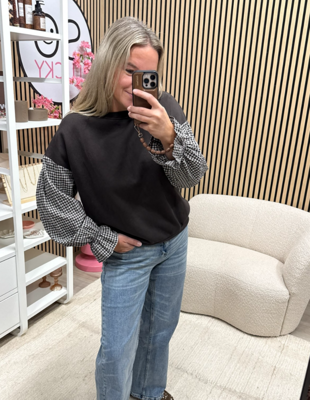 Model draagt bruine sweater met bruin witte ruitjesmouwen op jeans - So Lucky