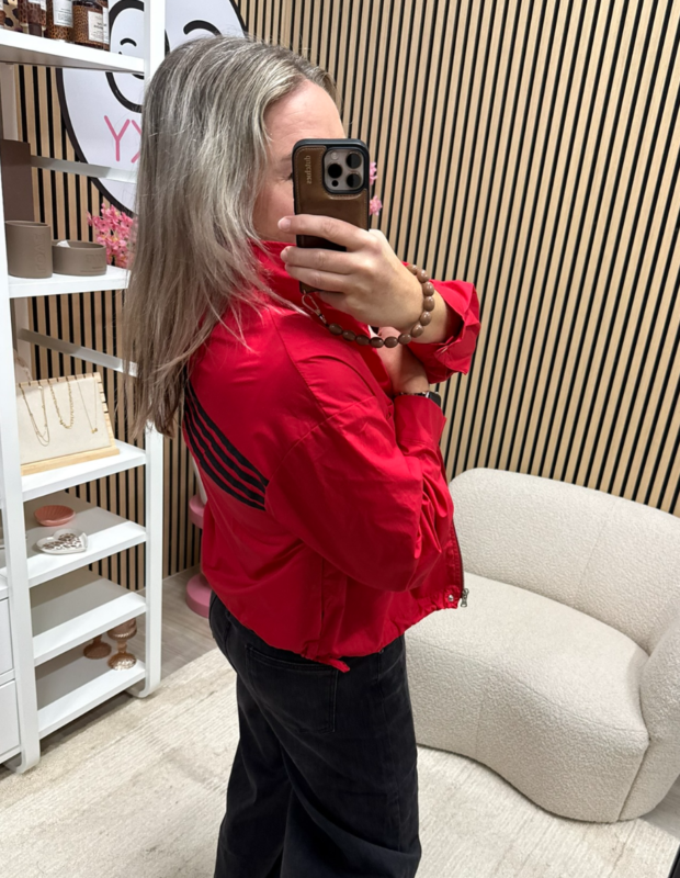 model draagt sportief rood blouse-jack op zwarte jeans - So Lucky